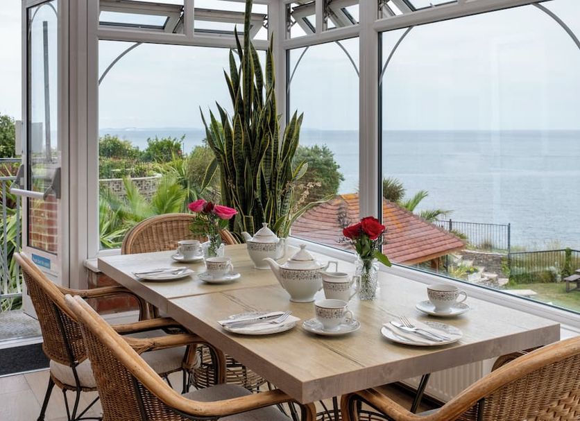 Grand Hotel Swanage dining area with table set by floor-to-ceiling windows and sea view