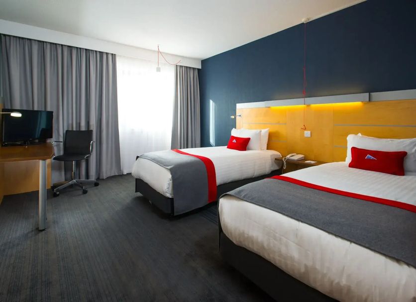 Holiday Inn Express Leeds - City Centre By IHG room with two beds, desk, TV and city-view window in Leeds