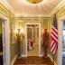 Fairfield Manor Bed and Breakfast in Shreveport hallway with green walls, chandelier, and American flag