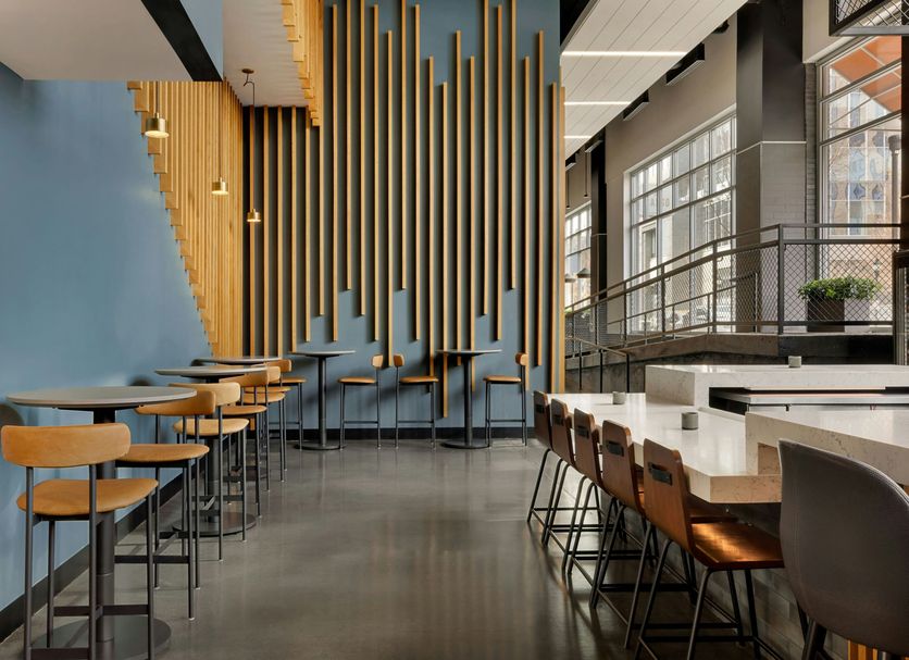 The Casso, Raleigh, a Tribute Portfolio Hotel bar and lounge with tall gold slat wall and high-top seating
