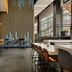 The Casso, Raleigh, a Tribute Portfolio Hotel bar and lounge with tall gold slat wall and high-top seating