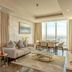 Swiss-Belsuites Admiral Juffair in Manama living room with floor-to-ceiling city view and dining area