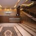 Zifan Hotel & Suites lobby in Karachi with reception desk, patterned rug, armchair and staircase