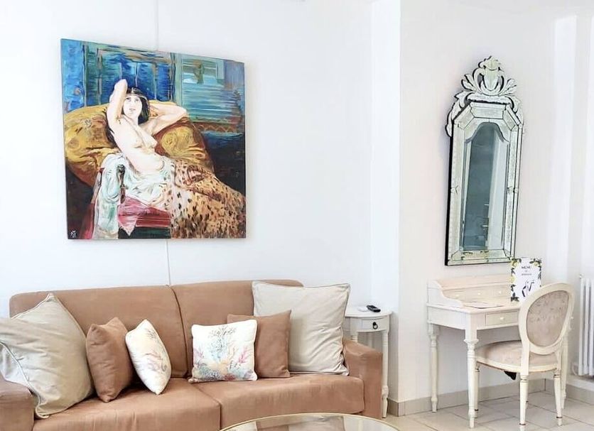 Hotel Normandy in Cap-d’Ail living area with tan sofa, ornate mirror and vanity desk