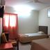 Skudai Baru Hotel in Skudai guest room with two single beds, window curtains, wall art and chair