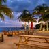 Buoy Haus Beach Resort St. Thomas, Autograph Collection beachfront dining with palm trees and string lights at dusk