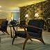 Movich Casa del Alferez in Cali lounge with black armchairs, patterned wall, and warm ambient lighting
