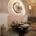 Riad Enchanté in Marrakech with ornate lounge seating, low table, and carved wall decor