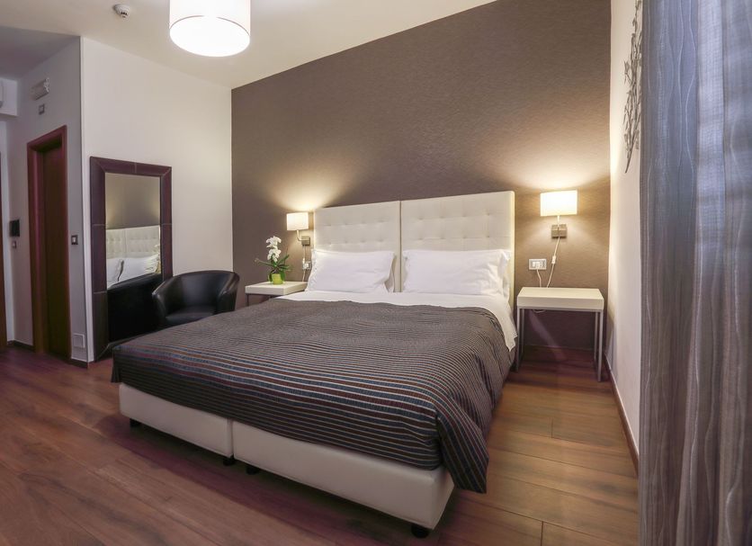 B&B Night&Day Reggio Calabria bedroom with double bed, wall lamps, mirror and wood flooring