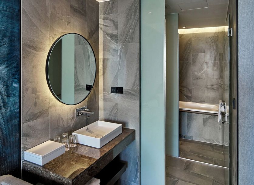Harbour 10 Hotel in Kaohsiung City bathroom with marble vanity, round mirror and glass shower