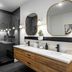 Mint House Dallas Downtown By Kasa bathroom with glass shower, double vanity and arched mirrors in Dallas