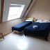 Au Pied Levé in Trévron: attic hotel room with two single beds under a skylight.