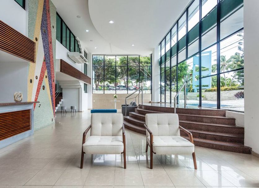 Joao Pessoa Hplus Beach lobby with lounge chairs and floor-to-ceiling windows in João Pessoa