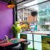 The Aim Patong Hotel bar area with purple wall, small table, and street view in Patong