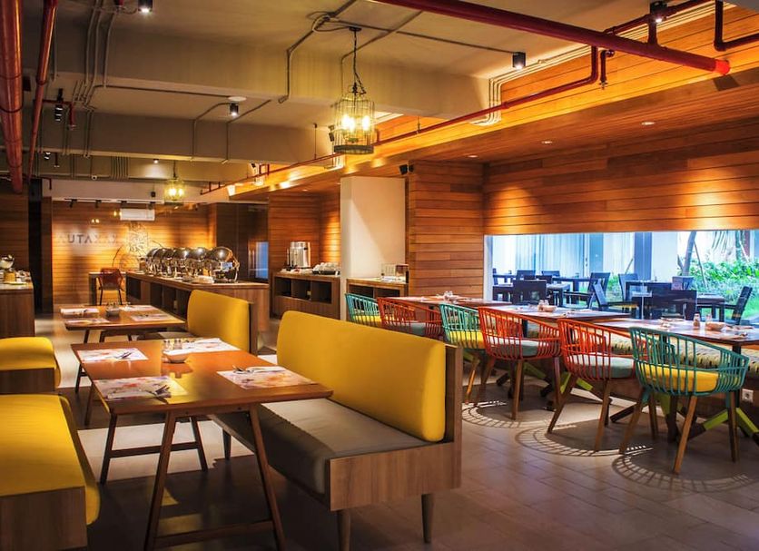 Tijili Hotel Benoa in South Kuta dining area with wooden booths and colorful chairs
