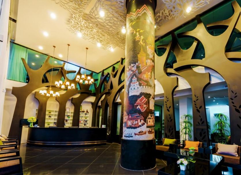 Raha Grand Hotel Patong lobby with reception desk, chandelier lighting, and ornate columns