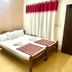 Sea Shell Haris Beach Home room in Kannur with double bed, wooden frame, and red-and-white curtains