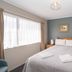 Trafalgar Lodge Nelson bedroom with double bed, window light, and framed wall art