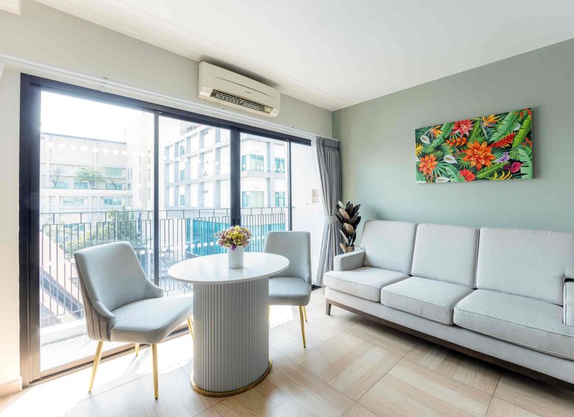 Chiva Bangkok Hotel in Bangkok: bright suite with balcony, seating area and tropical wall art