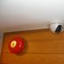 Ideal Hotel Pratunam Bangkok ceiling security camera and fire alarm above wood-paneled wall