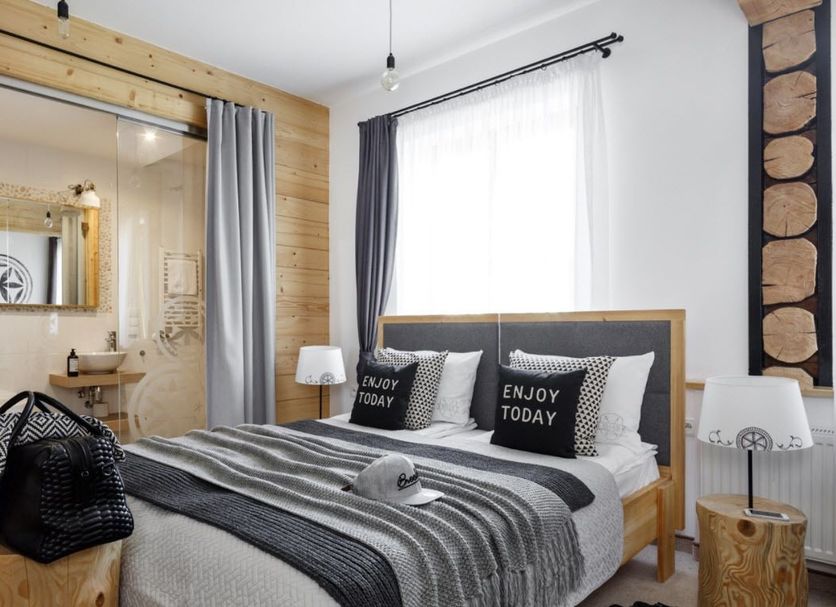 Villa 11 Folk & Design, Zakopane: bedroom with wood accents, glass bathroom, and large window