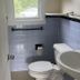 Village Green Motel in South Yarmouth bathroom with toilet, sink, towel bar, and window