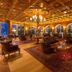 Grand Hotel Zell am See lobby with ornate wood ceiling, chandeliers, arched windows and seating