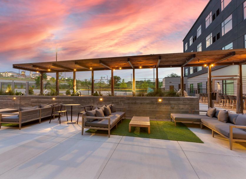 Cambria Hotel Austin Airport rooftop terrace with lounge seating and sunset sky in Austin