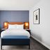 Hyatt Regency London Stratford guest room with king bed, blue bench and armchair in London