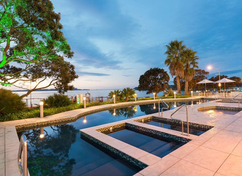 Paihia Beach Resort & Spa Hotel in Paihia with an outdoor pool, spa pools and ocean views at sunset