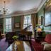 The Bedford Hotel, Tavistock: elegant lounge with green walls, fireplace, piano, and chandelier