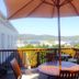 Knysna Manor House terrace with round table, umbrella and scenic Knysna hillside view