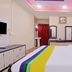 Hilltown Hotel in Madikeri room with king bed, colorful runner, dresser and mirror