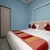 OYO 9231 Hotel Jinesh Jaipur room with bed, red accents and blue walls