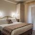 Hotel Il Tiglio in Castel di Sangro bedroom with bed, wardrobe and sheer balcony door curtains