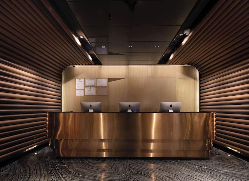 Paco Hotel Guangzhou Jiangtai Road Metro Branch lobby front desk in Guangzhou with sleek bronze reception area