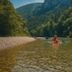 Canoeing on the river in Gorges-du-Tarn-Causses near Château de la Caze, with forested cliffs