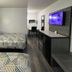 Motel 6 Meridian Ms room with two beds, TV, desk and dark wood furnishings in Meridian
