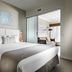 Grand Hotel and Apartments Townsville bedroom with king bed, balcony doorway and lounge area in Townsville