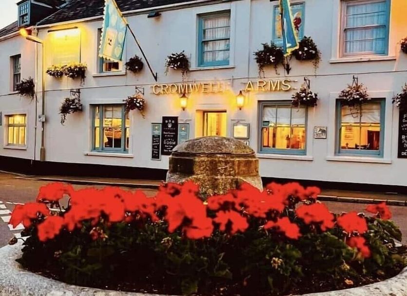Cromwell Arms in Newton Abbot exterior with flower planter and illuminated entrance
