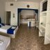 Hotel Paraiso Kora in San Blas: simple room with two beds, blue accents, and kitchenette area