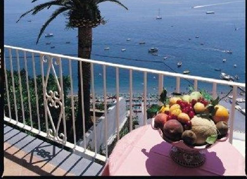 Hotel L'Ancora in Positano with sea view, palm tree, balcony railing and fruit bowl