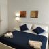 Palazzo Verdi Holiday Viterbo in Viterbo, a bright room with a bed dressed in navy bedding and wall art
