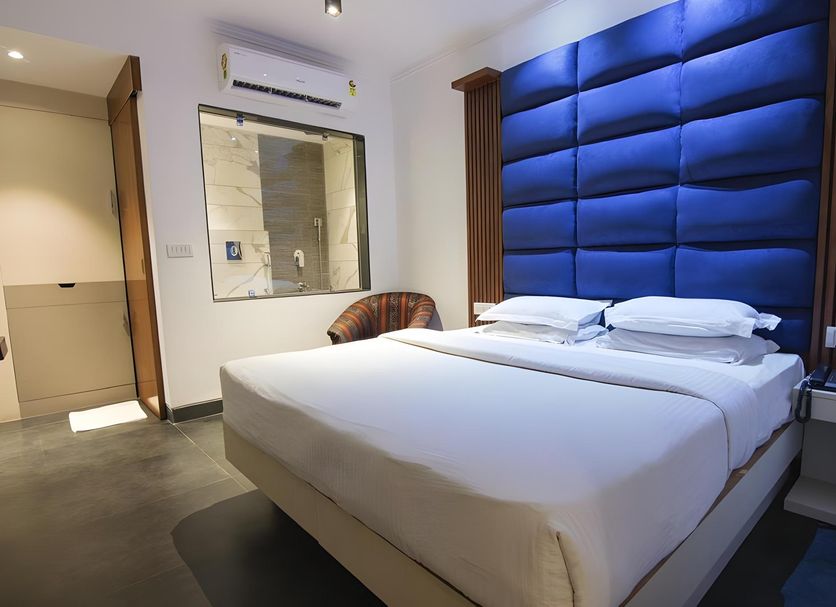 Sri Nanak Continental Hotel, New Delhi guest room with king bed and blue padded headboard