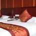 Yiwu Mango Hotel in Jinhua: twin beds with red patterned runners and pillows in a guest room