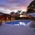 Novotel Campo Grande pool area at sunset with lounge chairs and a city skyline in Campo Grande
