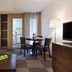 Residence La Reserve Ferney-Voltaire room with seating area, dining table, TV, and kitchenette doorway