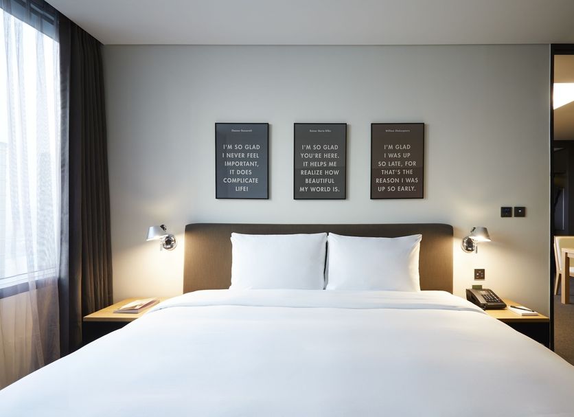 Glad Mapo Seoul guest room with king bed, bedside lamps and minimalist wall art