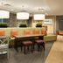 Home2 Suites by Hilton Anchorage/Midtown lobby seating area with tables, chairs, and pendant lights