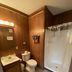 Denali RV Park and Motel in Healy bathroom with shower curtain, toilet, sink and wood-paneled walls